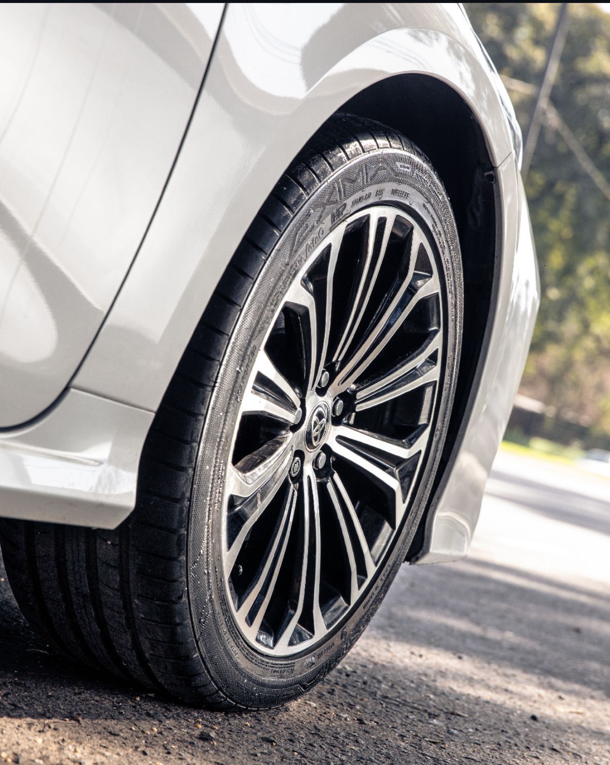 Un primer plano de una rueda de coche en un estacionamiento.