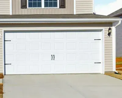 New white garage door replacement with top row windows for improved home curb appeal.