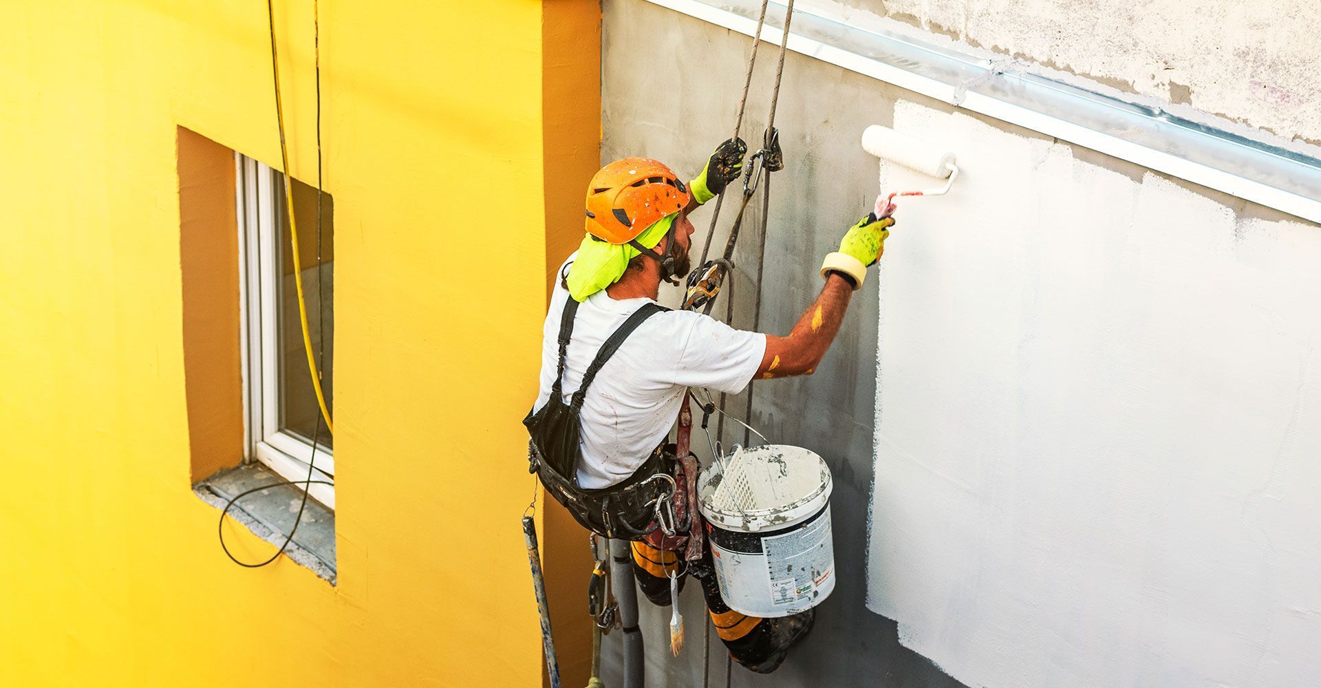 Man Painting the Exterior of a Commercial Building