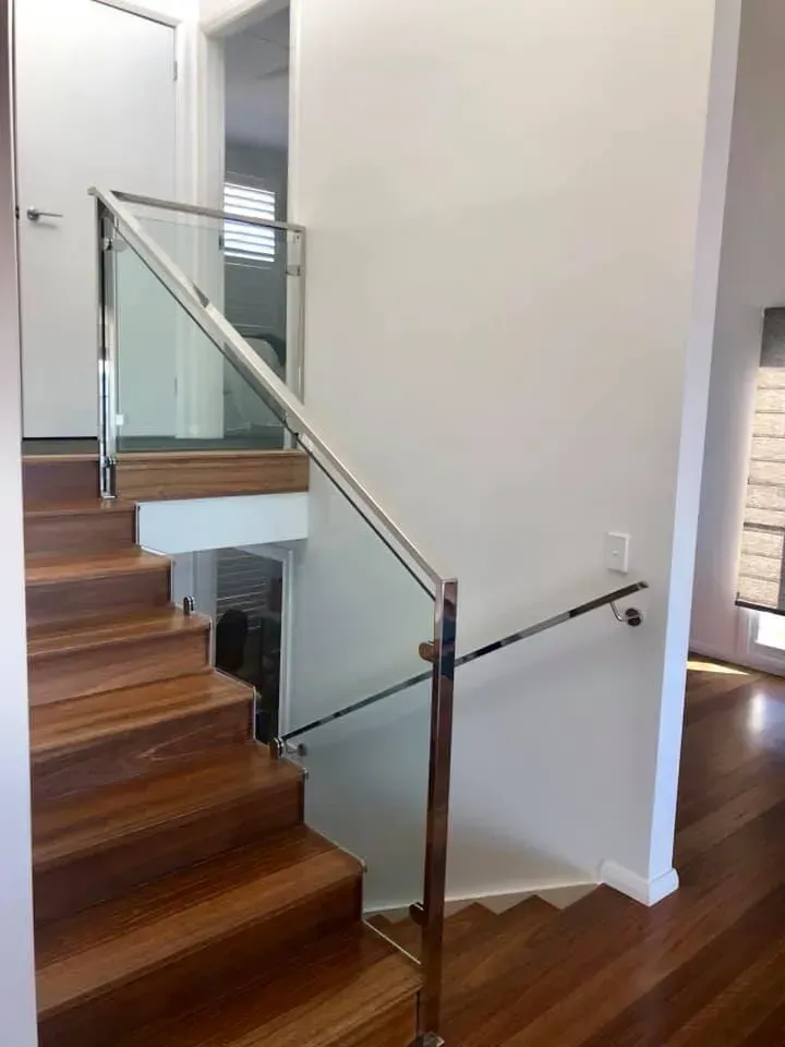 Wooden stairs with glass and steel railing.
