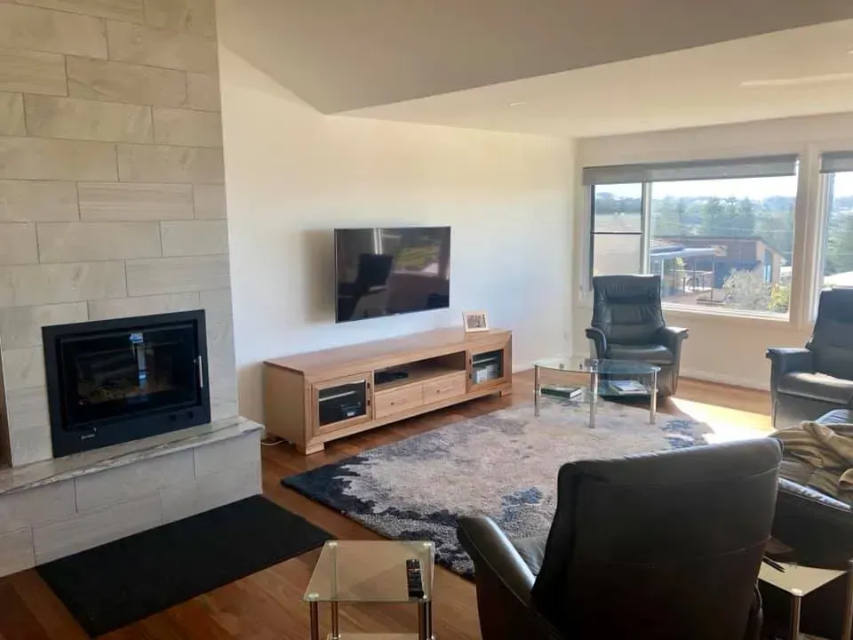 Living room with fireplace, TV, and seating area with a view.