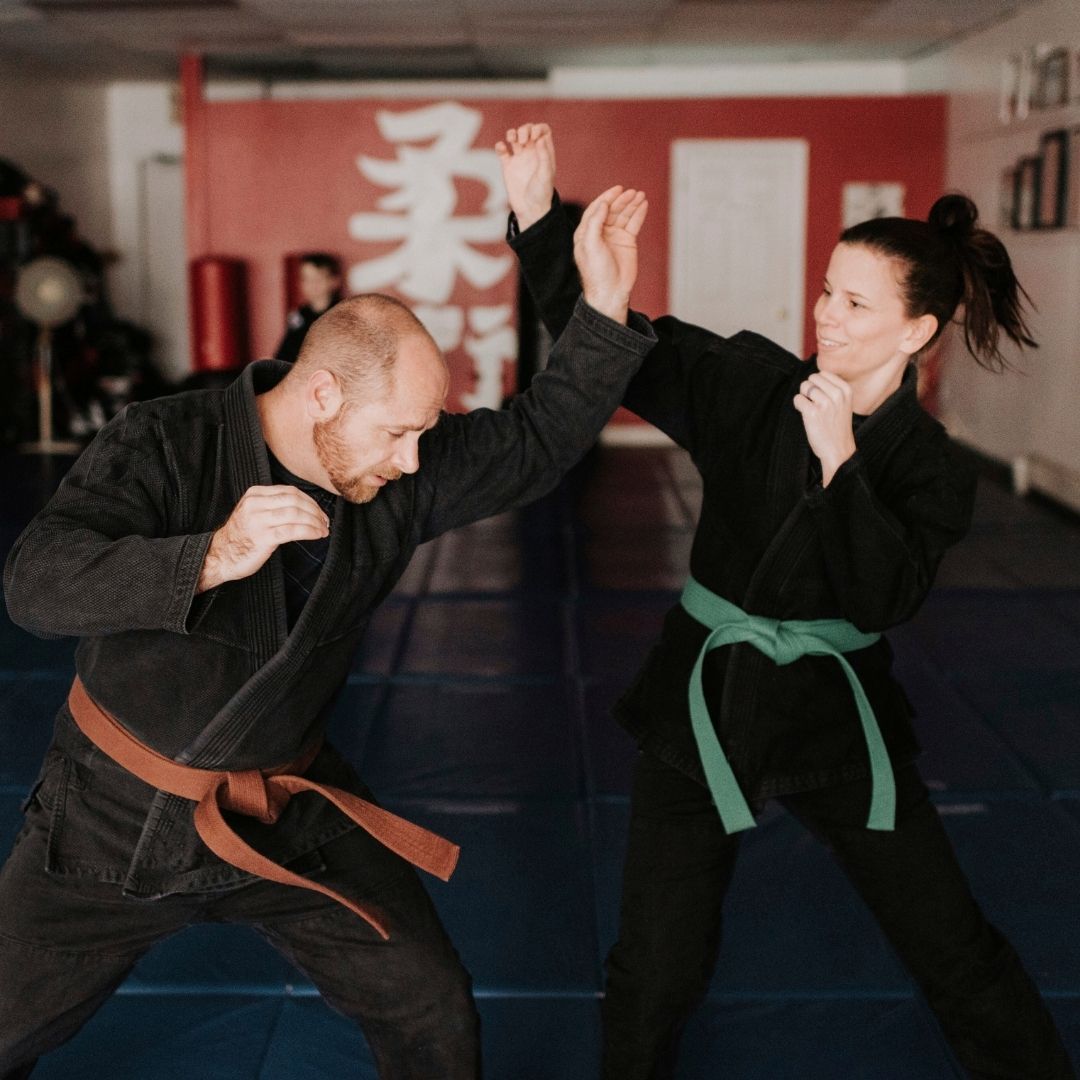 Two young men are practicing karate on a mat