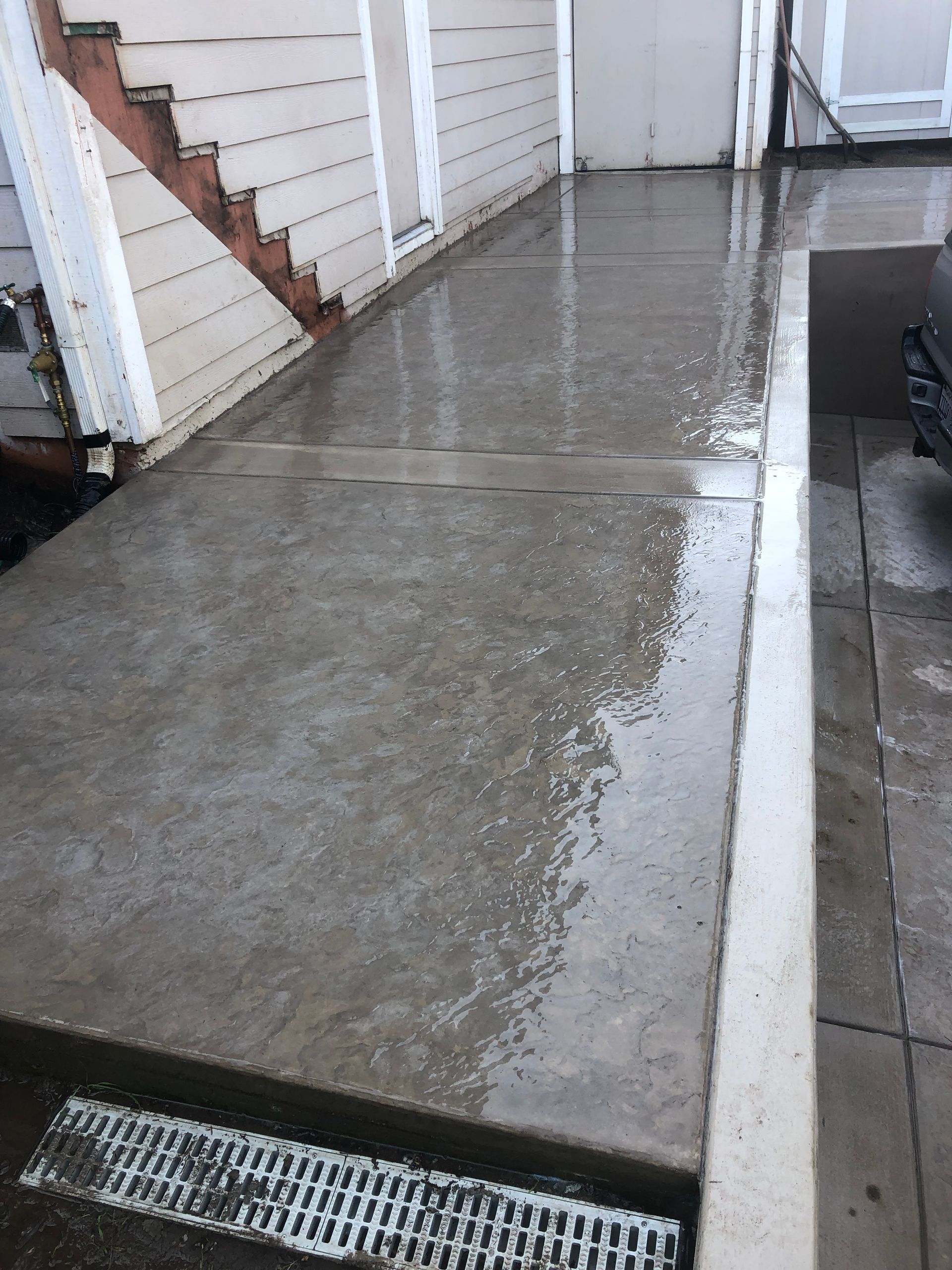 A construction worker wearing orange gloves is pouring concrete on a construction site.