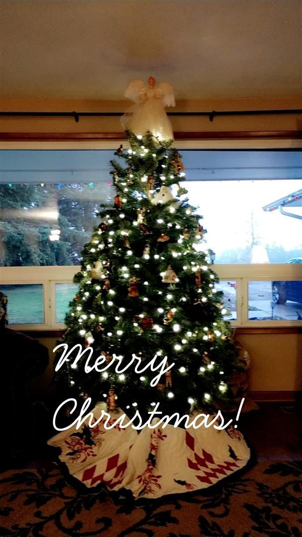 A christmas tree in a living room with the words merry christmas written on it | J&H Automotive