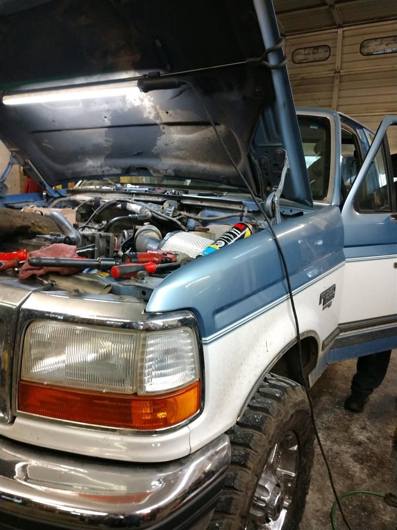 A blue and white truck with the hood open in a garage. | J&H Automotive