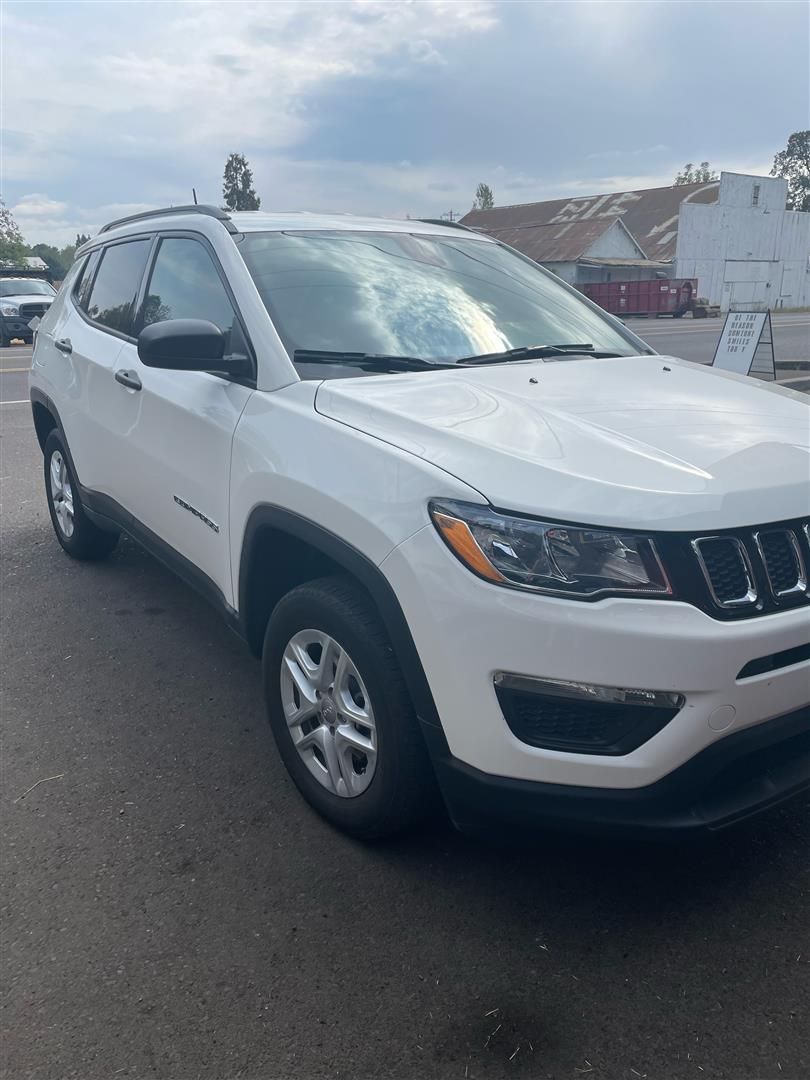 A white jeep compass is parked in a parking lot. | J&H Automotive Inc