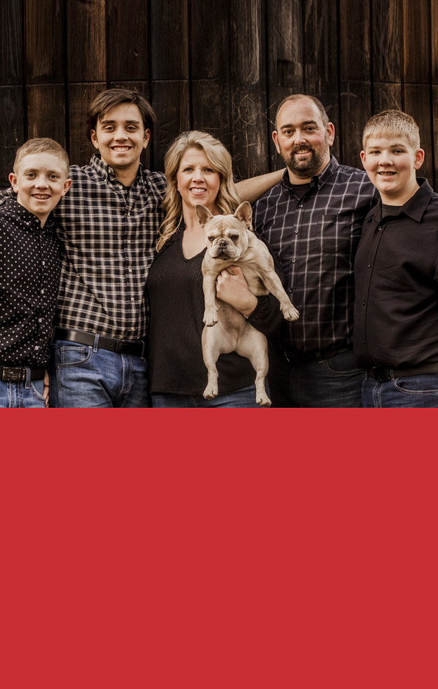 A family is posing for a picture with their dog. | J&H Automotive Inc