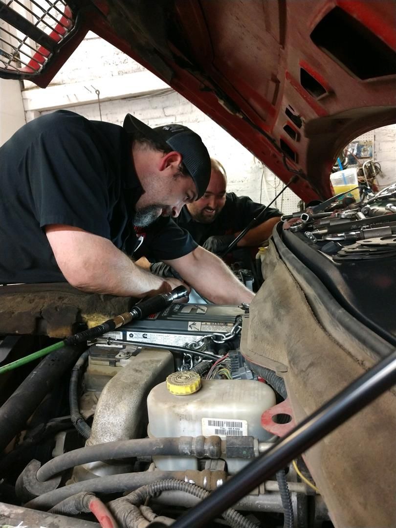 A man is working under the hood of a car. | J&H Automotive