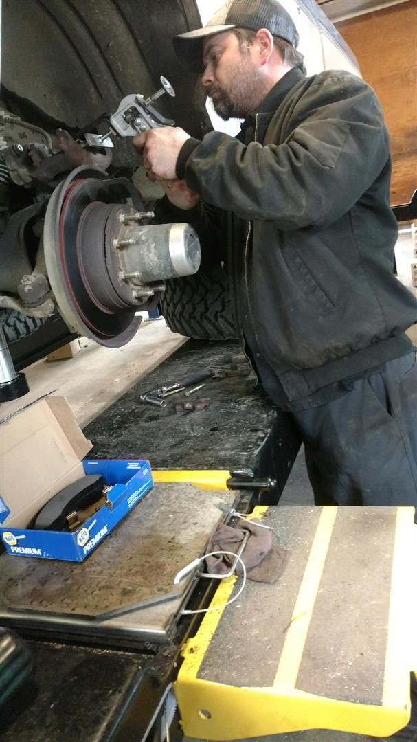 A man is working on a car in a garage. | J&H Automotive
