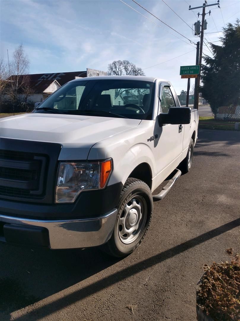 A white truck is parked on the side of the road.