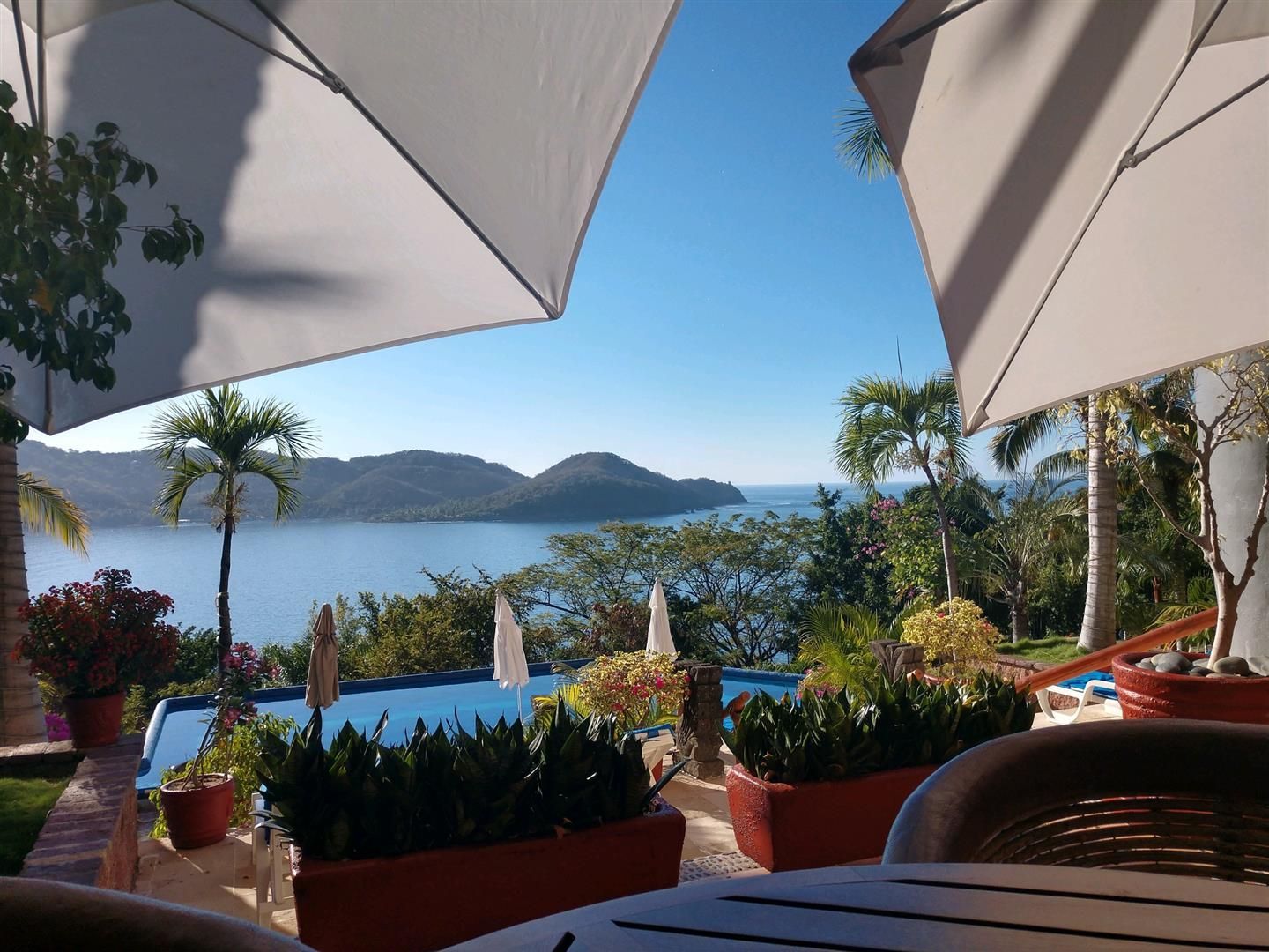 A view of the ocean from a table with umbrellas | J&H Automotiv