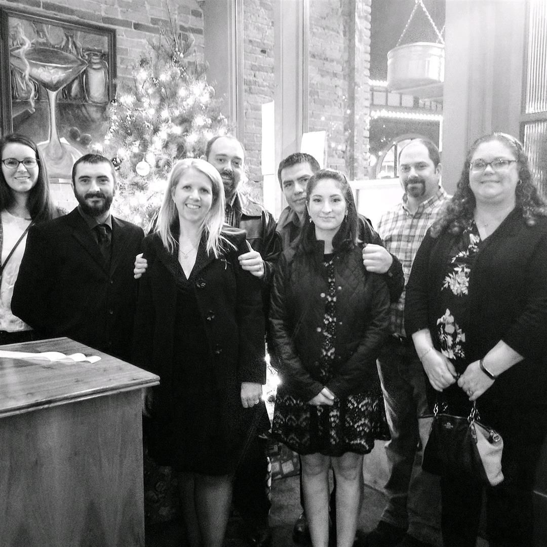 A group of people are posing for a picture in front of a christmas tree. | J&H Automotive