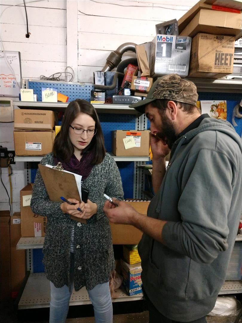 A man and a woman are looking at a clipboard in a store | J&H Automotive