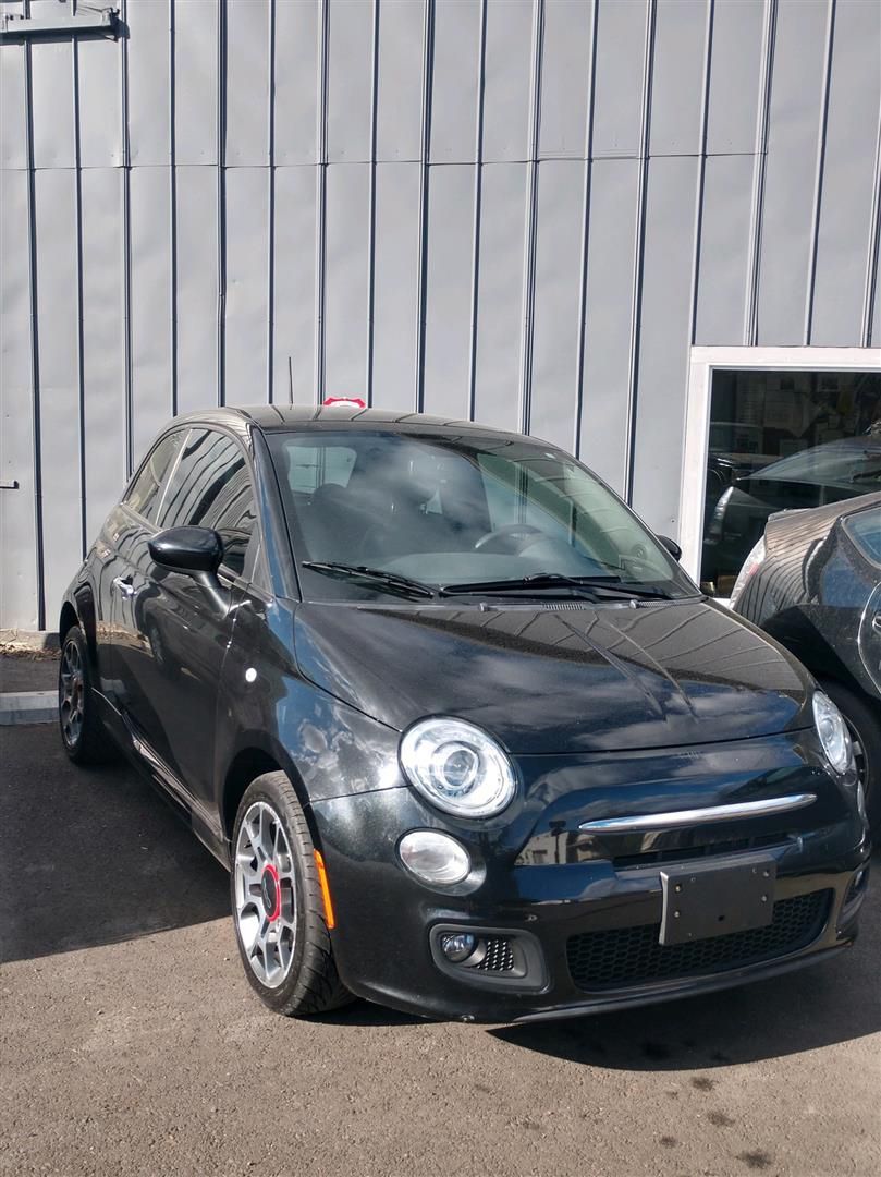 A black car is parked in front of a building. | J&H Automotive