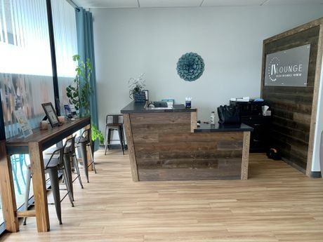 a reception area with a wooden counter and stools .