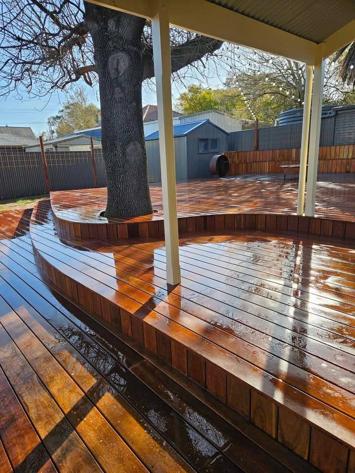 A wooden deck with a tree in the background.