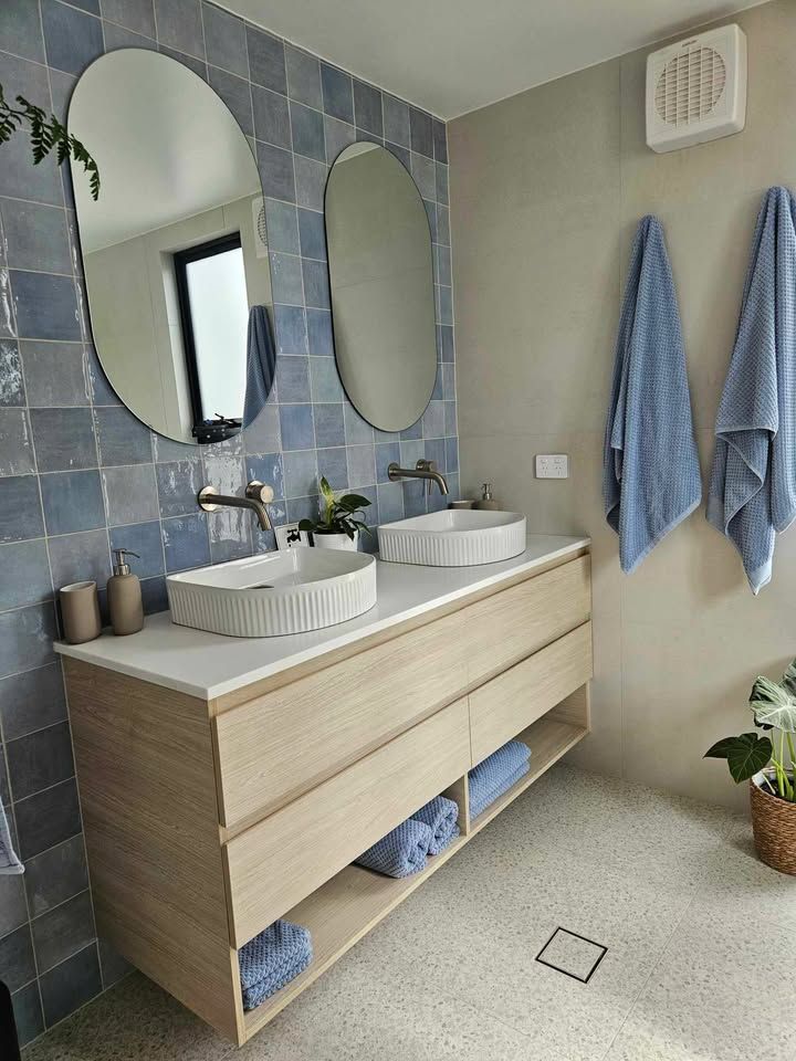 A bathroom with two sinks and two mirrors.
