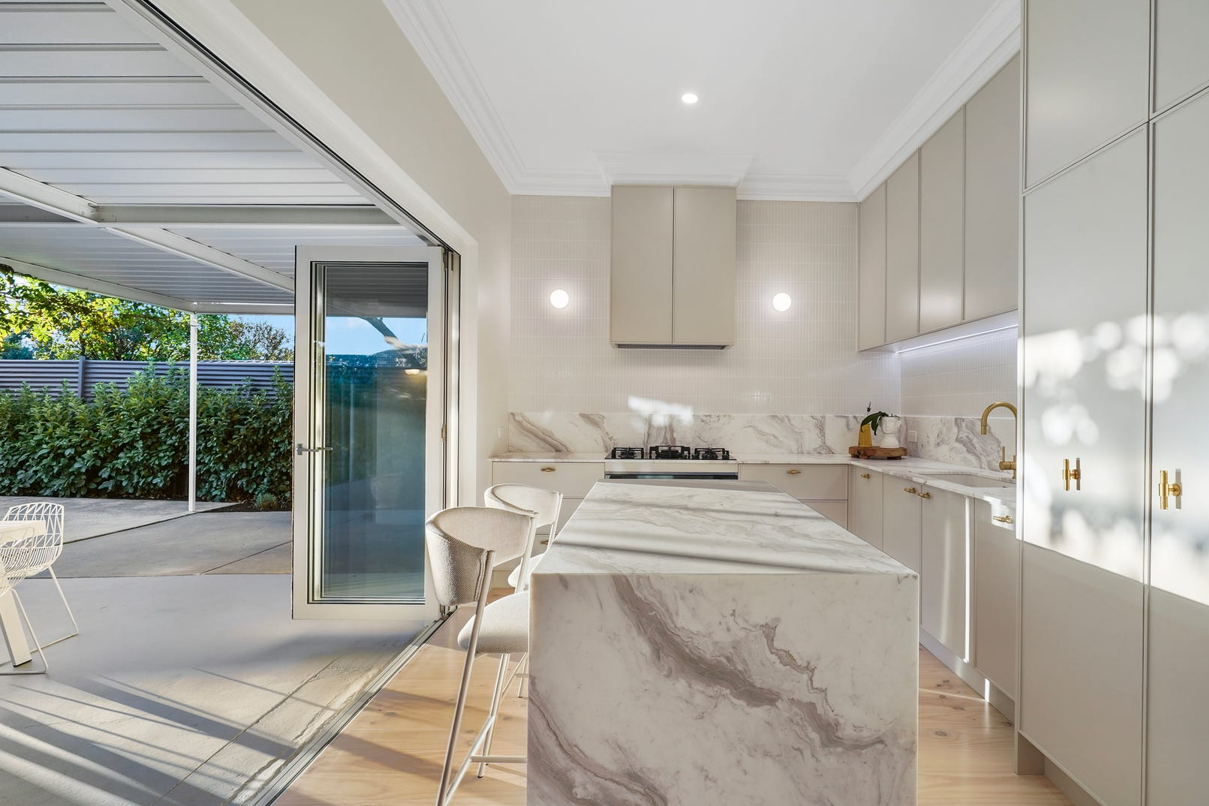 A kitchen with a large island and a sliding glass door leading to a patio.