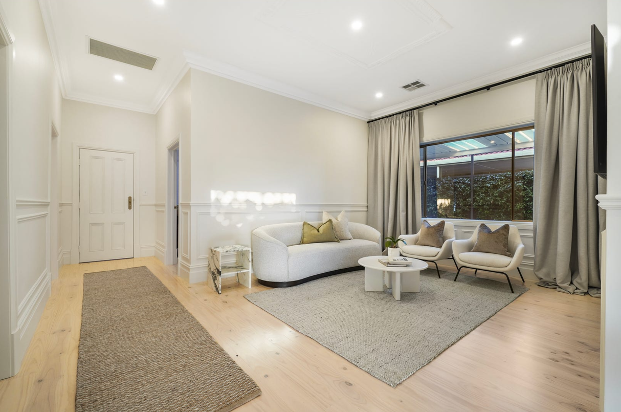 A living room with a couch , chairs , and a rug.