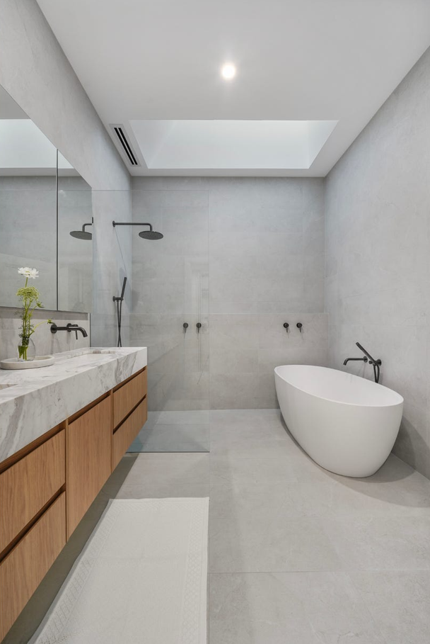 A bathroom with two sinks , a bathtub and a shower.