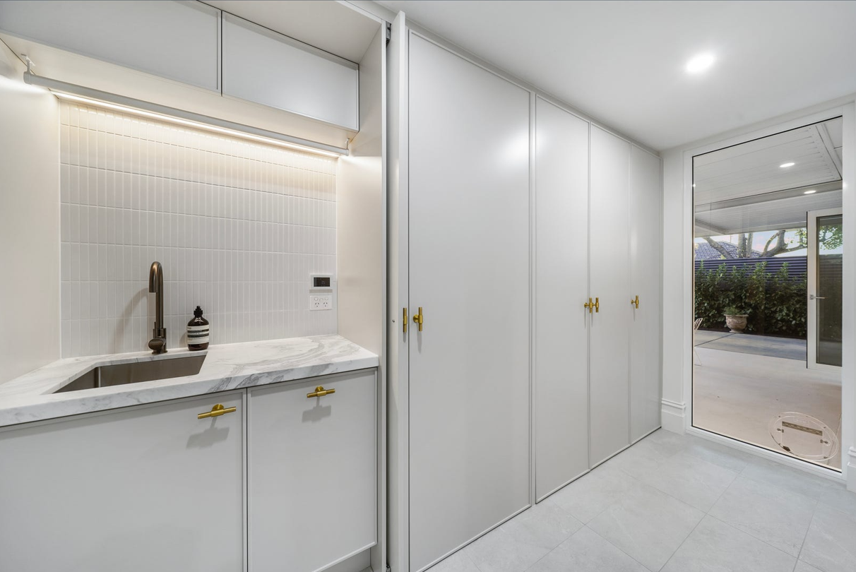 A bathroom with a washer and dryer stacked on top of each other.