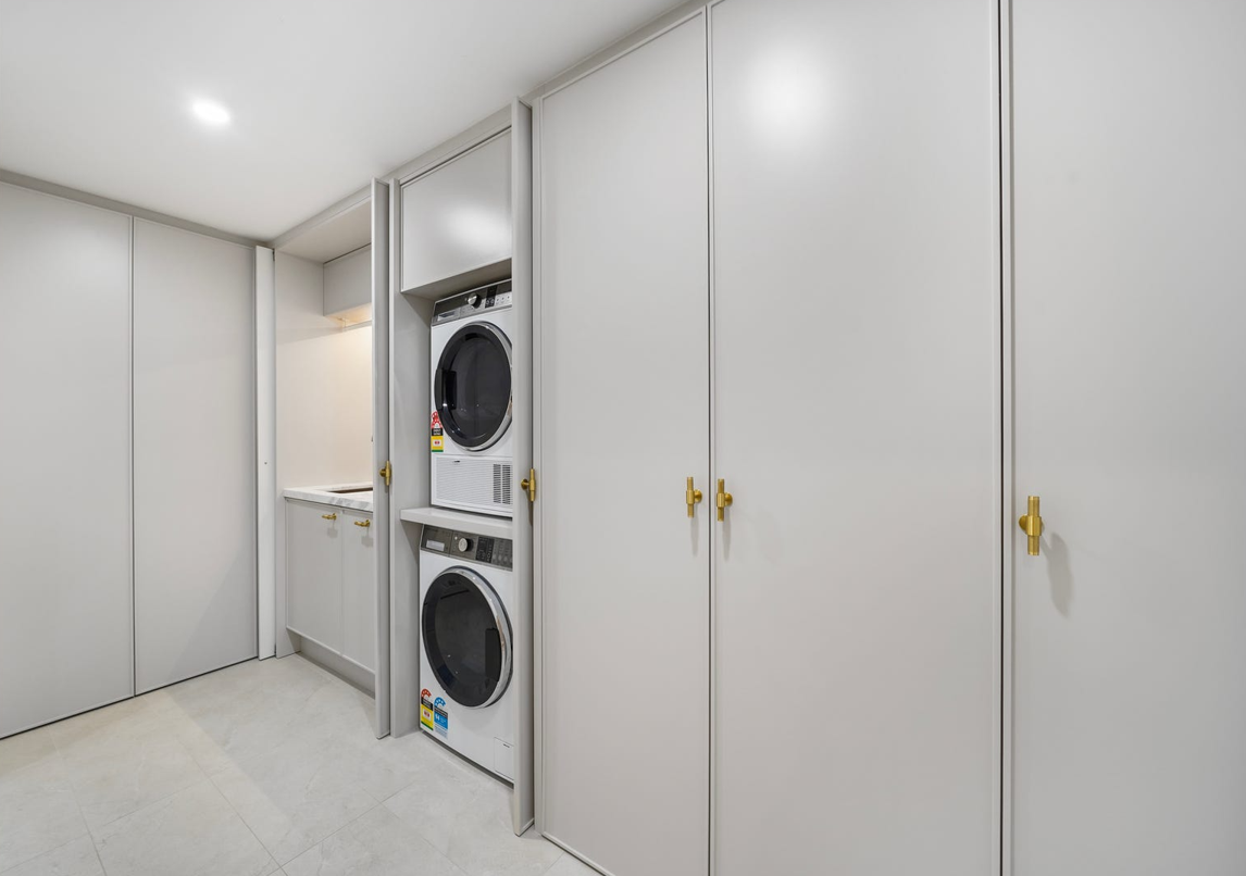 A laundry room with a washer and dryer stacked on top of each other.