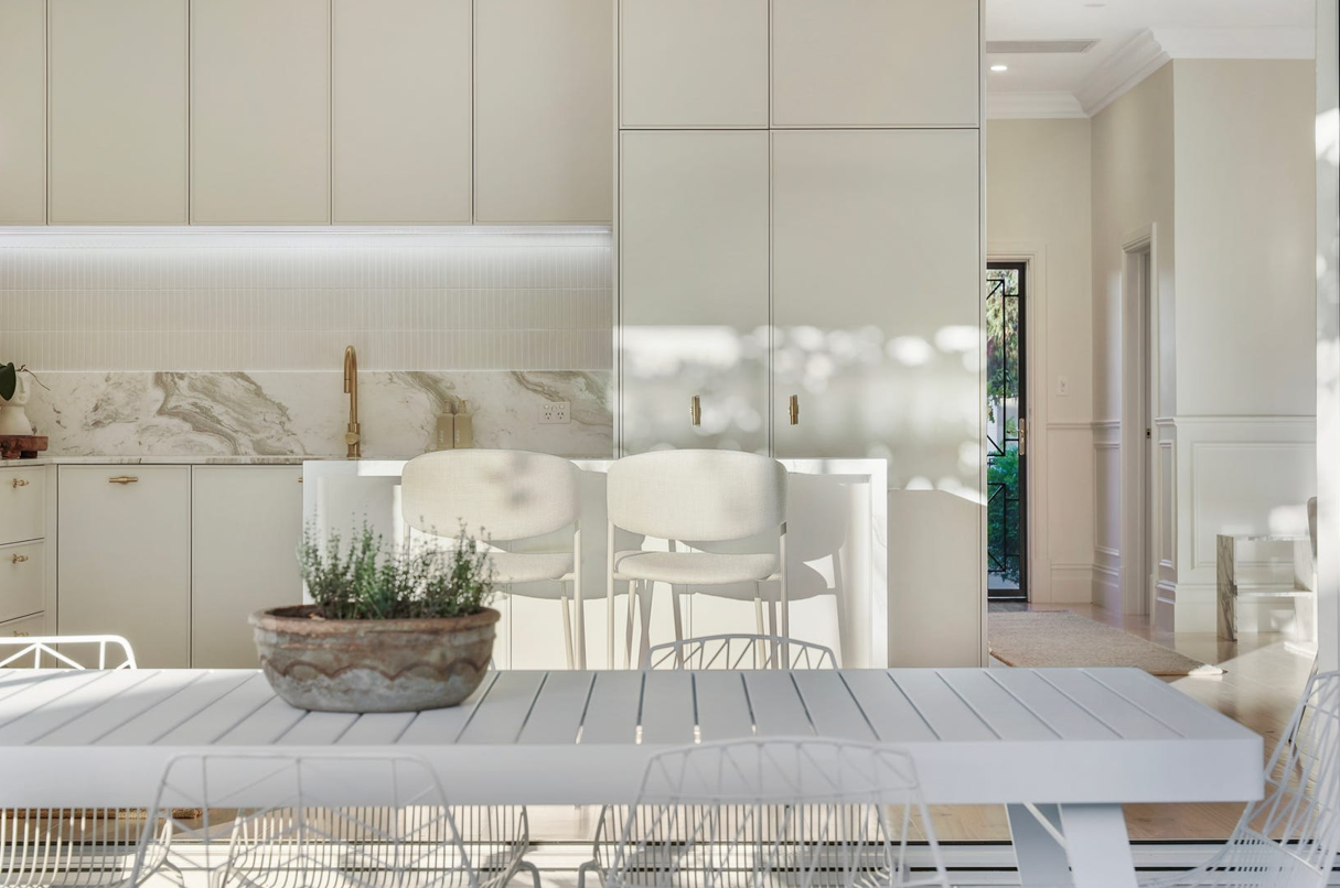 A white table with a potted plant on it in a kitchen.