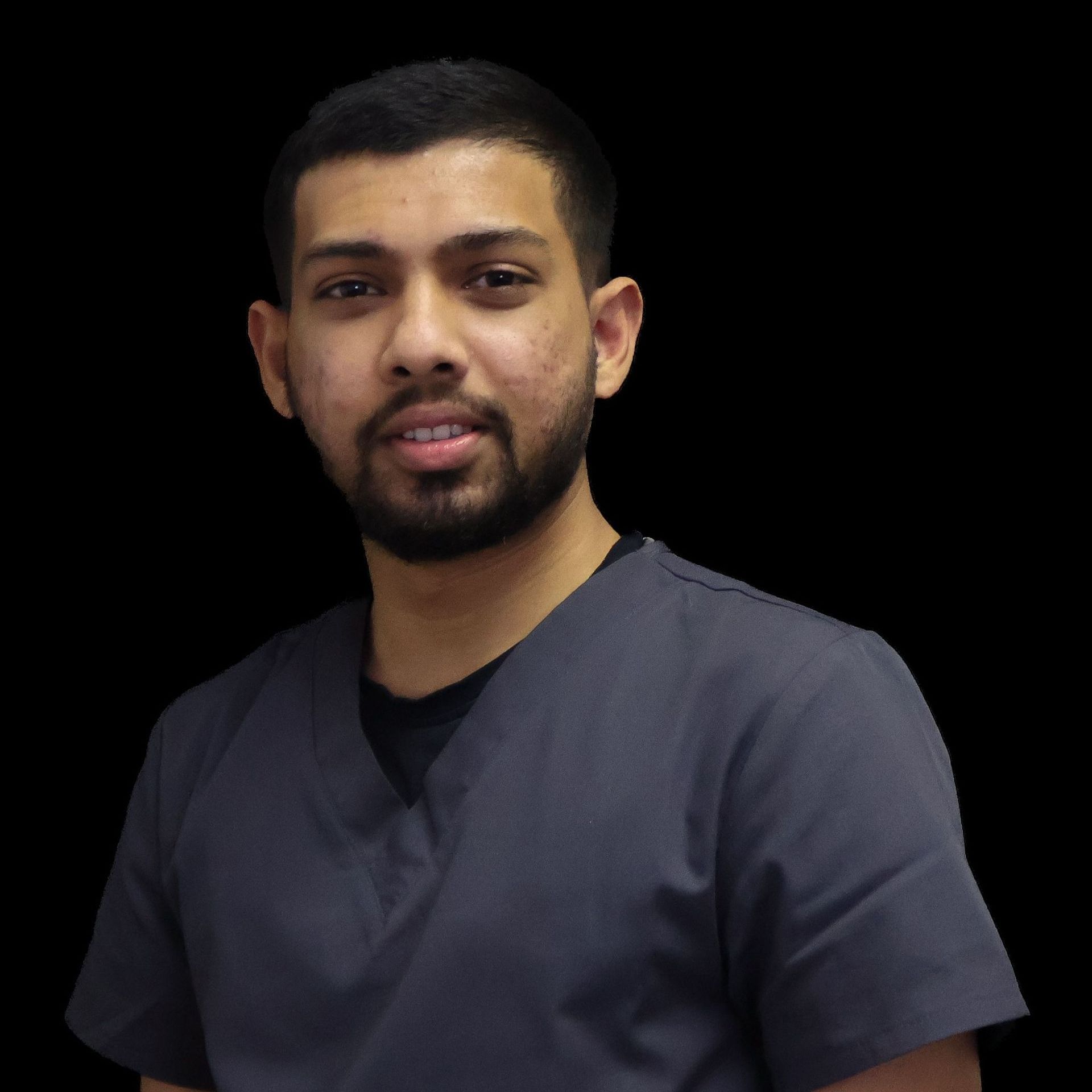 A man with a beard is wearing a scrub top and a black shirt.