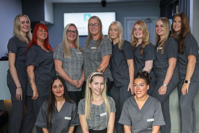 A group of women in scrubs are posing for a picture.