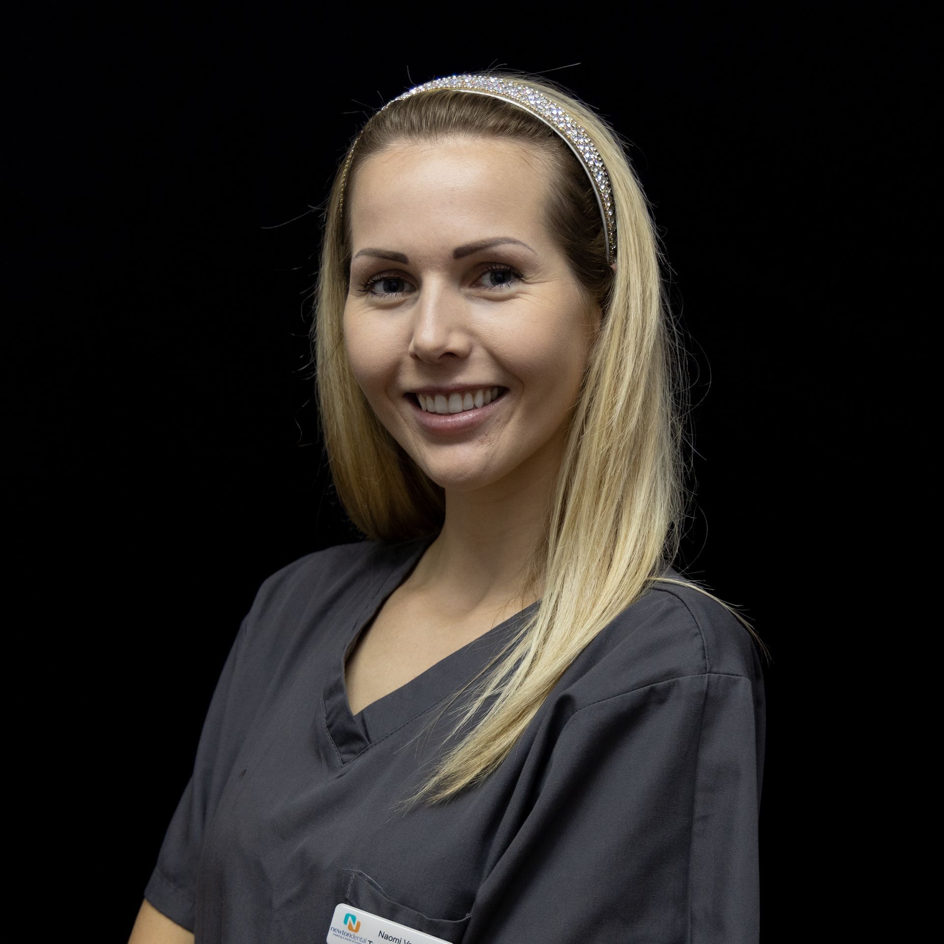 The woman is wearing a headband and smiling for the camera.