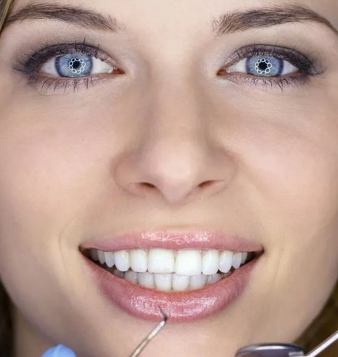 A close up of a woman 's face with a dental mirror in her mouth.