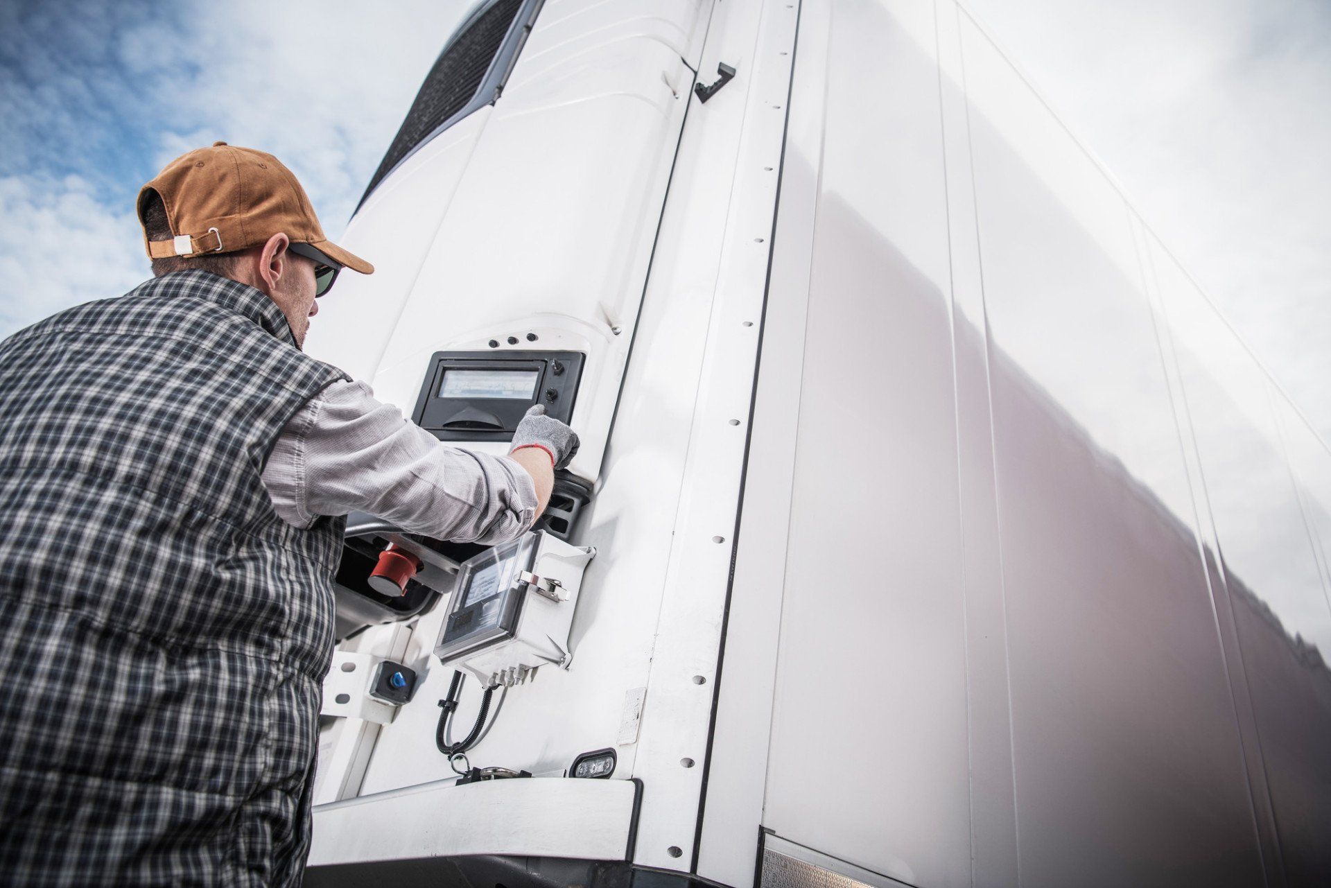 worker checking temperature on a refrigerated lorry