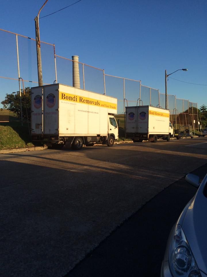Two Moving Trucks Are Parked on The Side of The Road — Bondi Removals and Taxi Trucks in Randwick, NSW