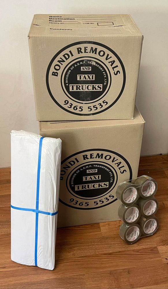 Two Boxes Are Stacked on Top of Each Other on A Wooden Table — Bondi Removals and Taxi Trucks in Randwick, NSW