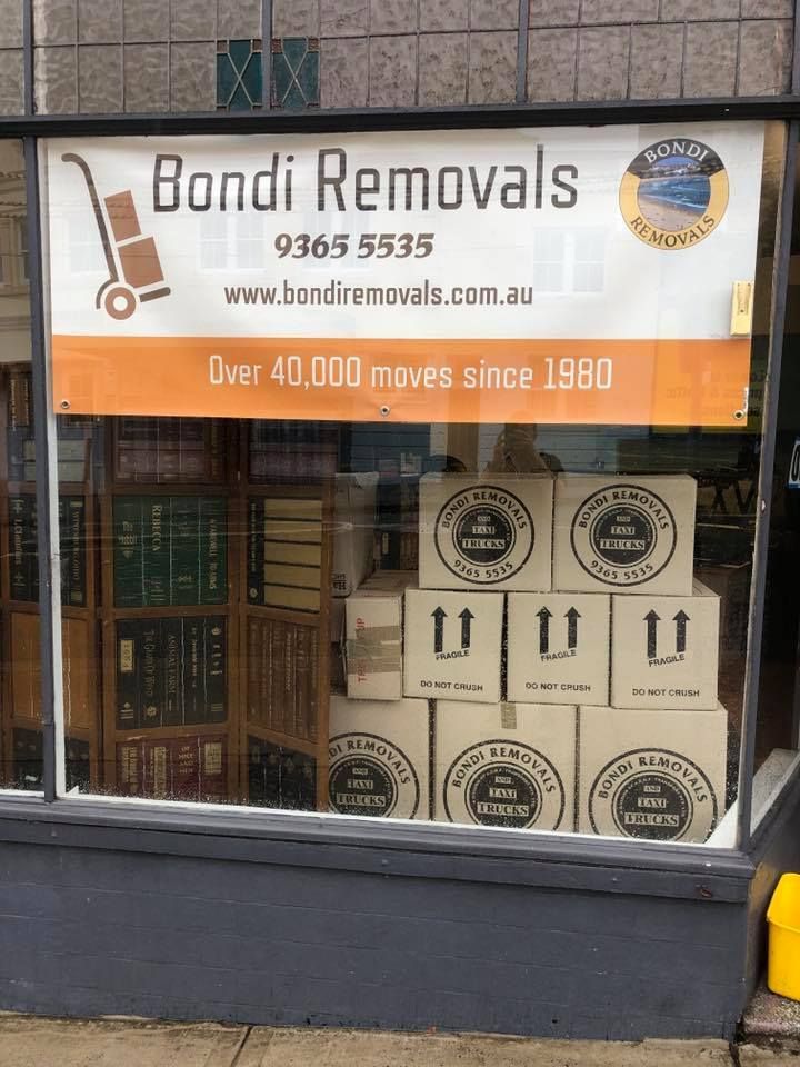 Boxes Are Stacked in Front of A Window for Bondi Removals — Bondi Removals and Taxi Trucks in Randwick, NSW