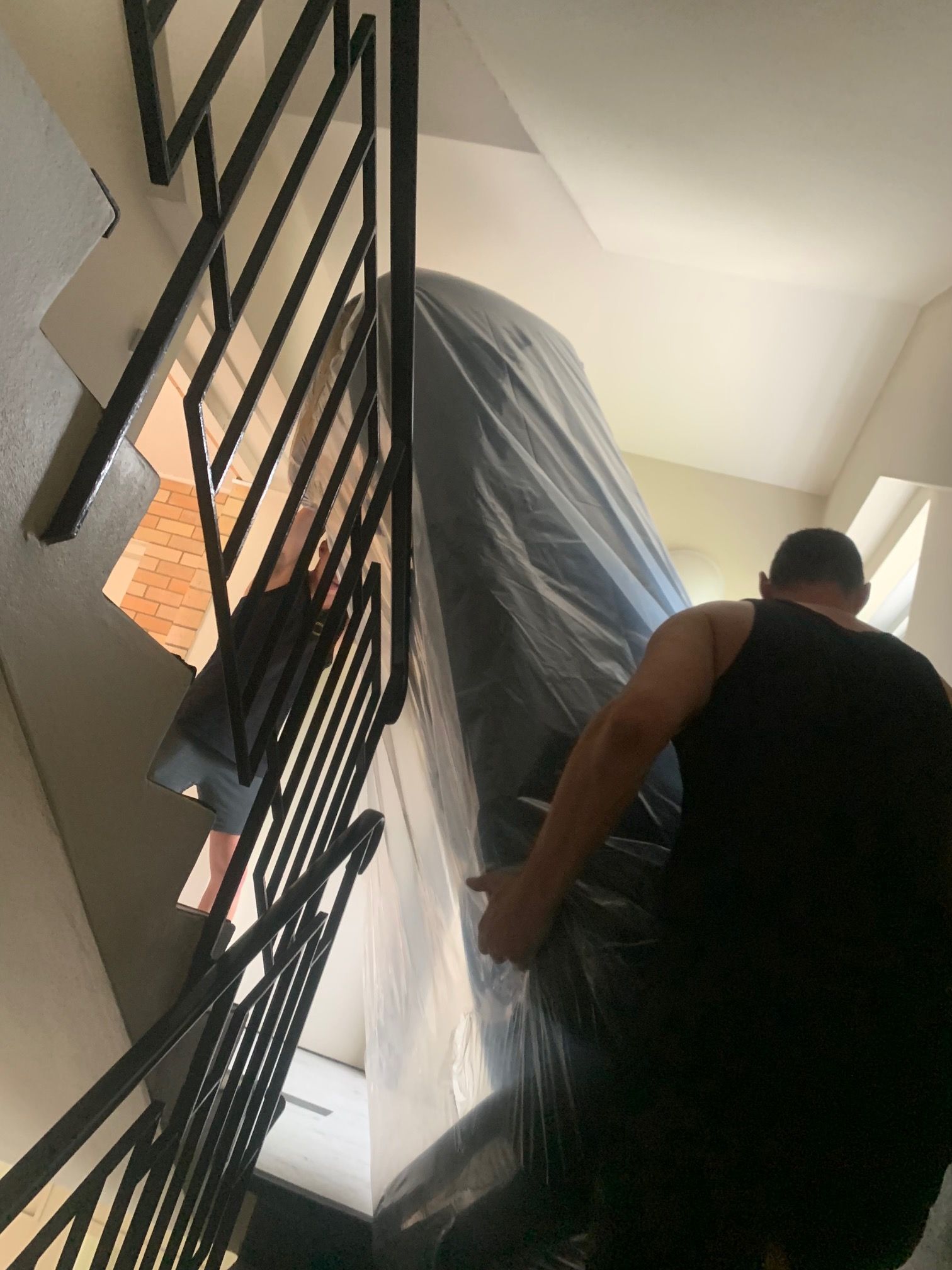 Two Men Are Moving a Piano in A Living Room — Bondi Removals and Taxi Trucks in Randwick, NSW