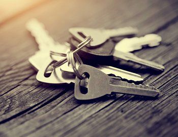 The bunch of keys lies on a wooden table.