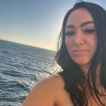 A woman is taking a selfie in front of the ocean