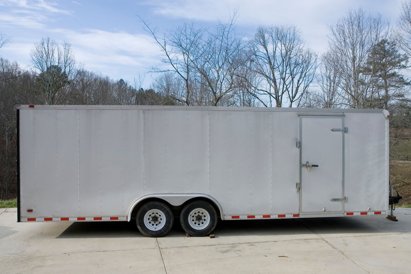 A white trailer is parked on the side of the road.