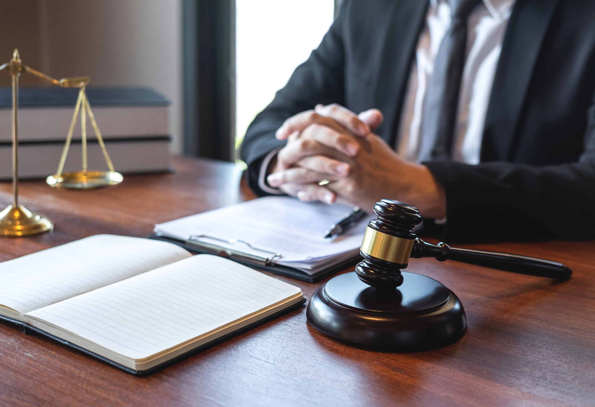 A wooden judge 's gavel is sitting on a table in front of a stack of books.