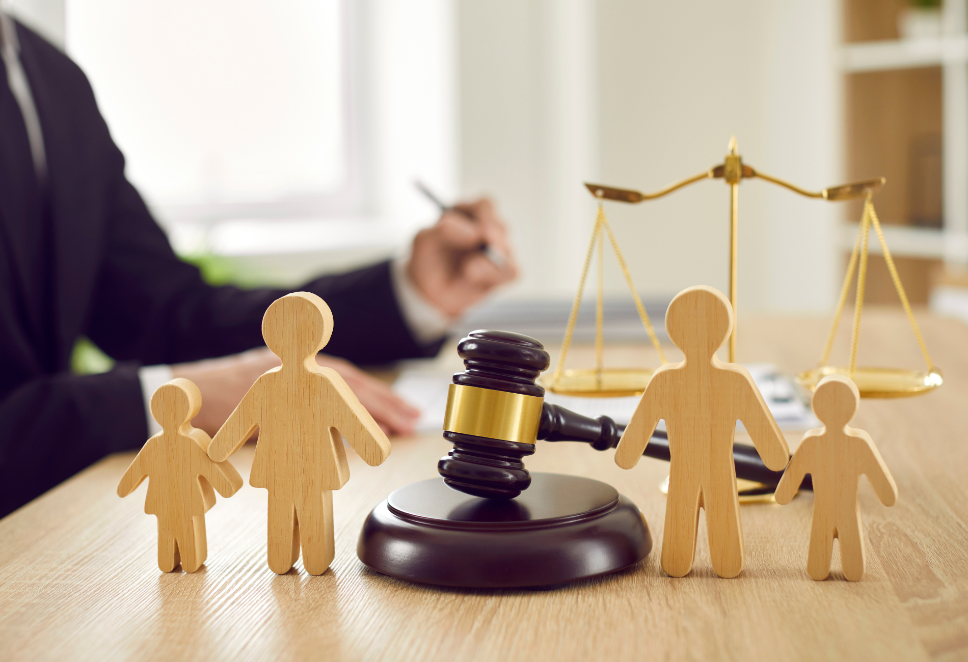 A judge 's gavel is sitting on a wooden table next to two people.