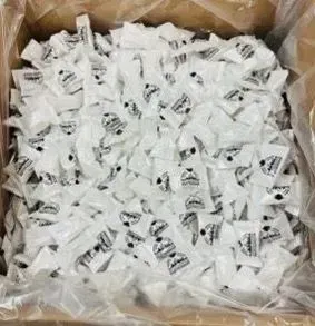 Box filled with many white individually wrapped candies.