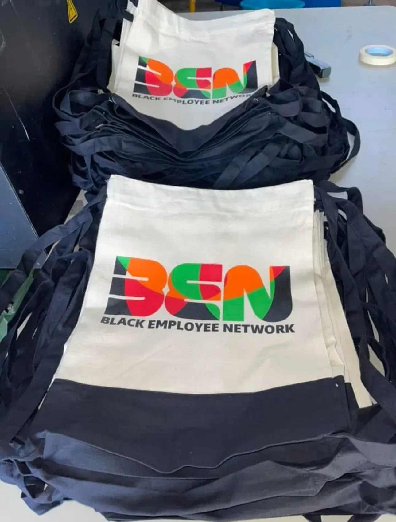 Stacks of white tote bags with the 