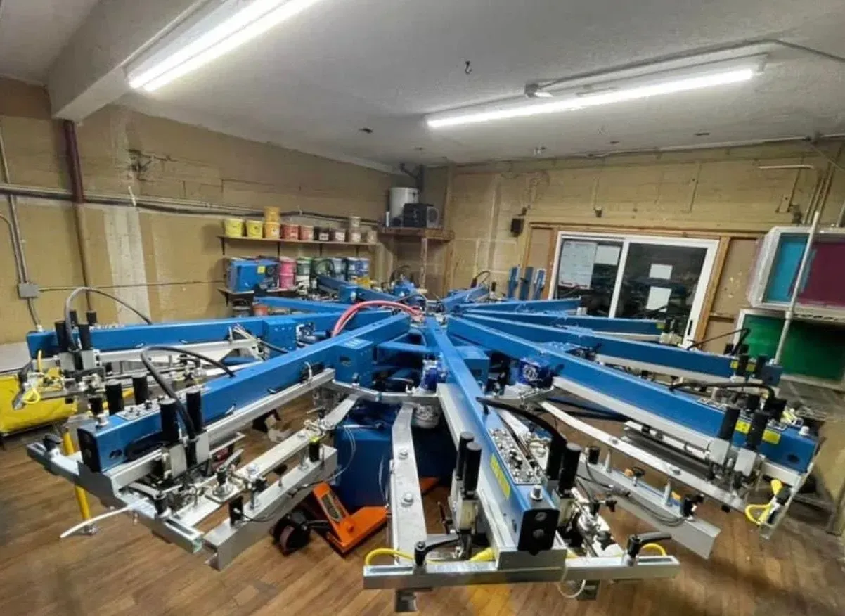 Blue screen printing machine in a workshop, ready to print.
