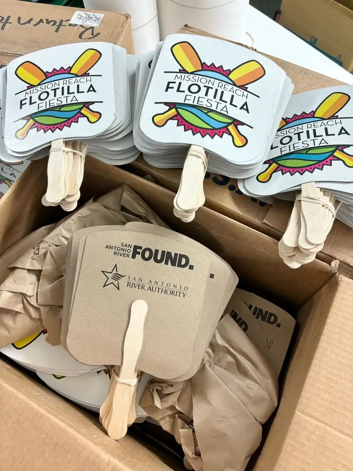 Boxes of promotional fans with event logos.