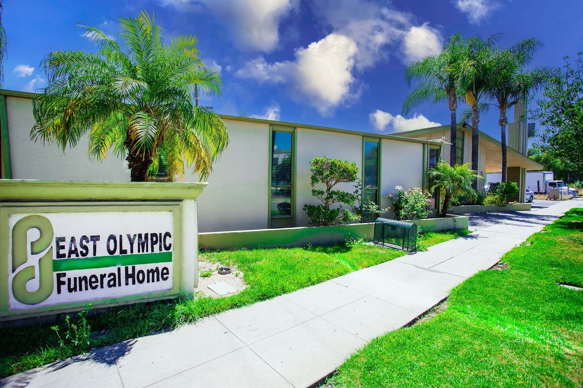 A sign for east olympic funeral home is in front of a building