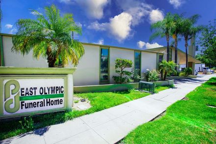 A sign for east olympic funeral home is in front of a building