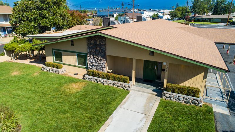 An aerial view of a house with a large lawn in front of it.