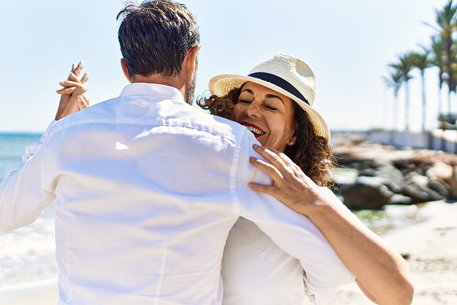 A man and a woman are dancing on the beach.