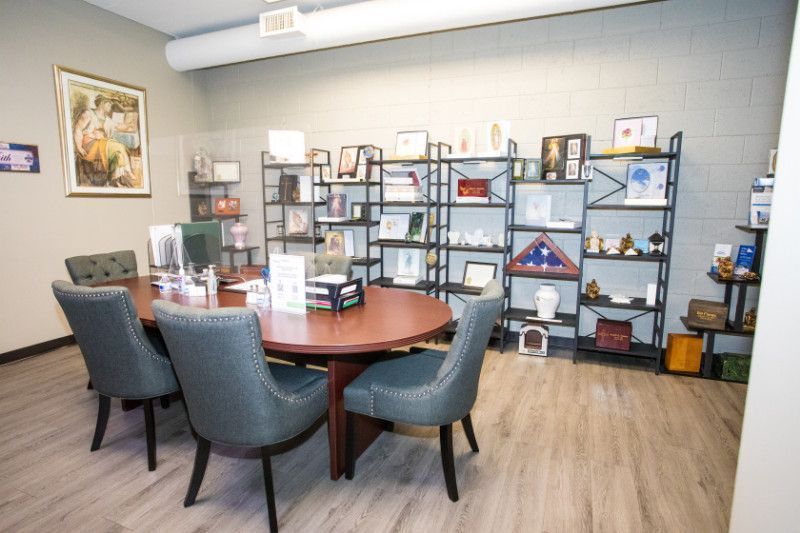 A conference room with a table and chairs and shelves filled with memorabilia.